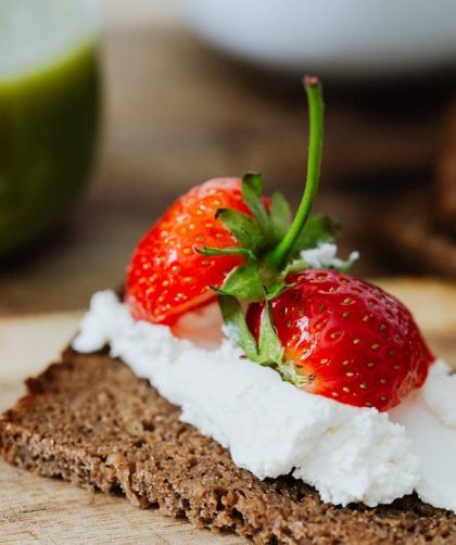 Rye bread topped with cream and juicy strawberries, perfect for a sweet treat.